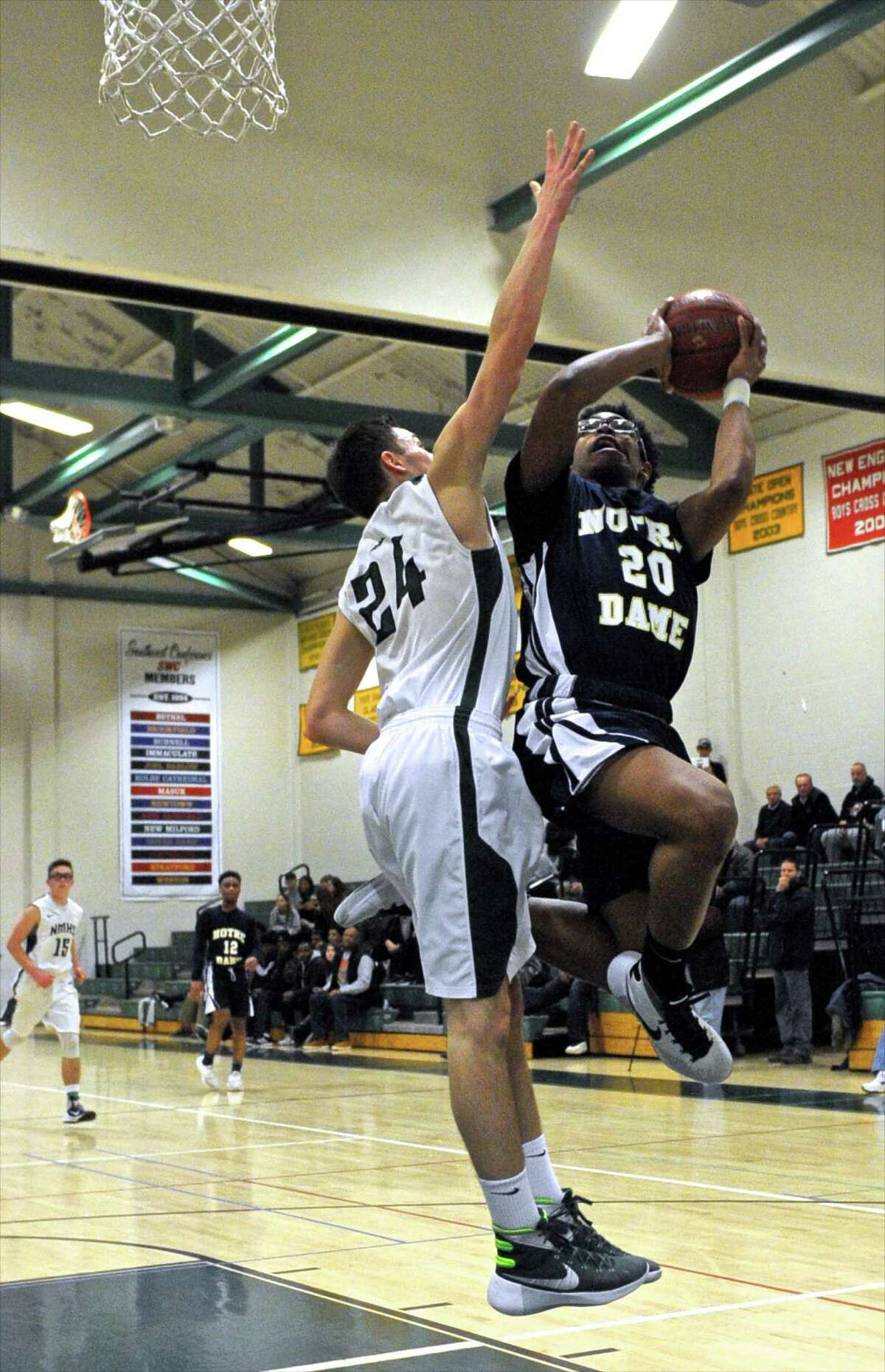 Notre Dame-Fairfield's Noreaga Davis (20) goes to the basket while New Milford's Reese Zimmerman (24) goes up for the block in the boys basketball game between Notre Dame-Fairfield and New Milford high schools on Friday night, February 19, 2016, at New Milford High School, in New Milford, Conn.