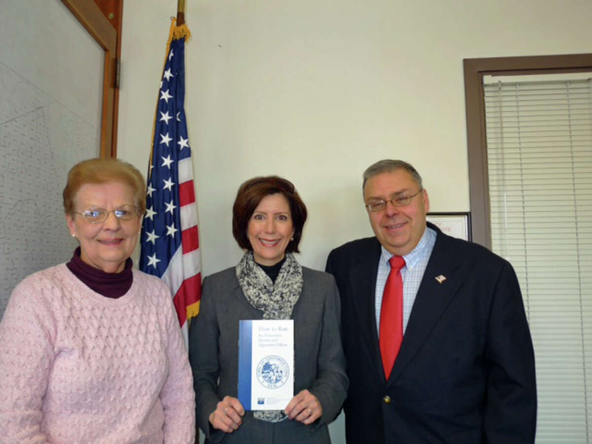 Registrars of Voters Sharon Vecchiolla, left, and Fred DeCaro III flank Deirdre Kamlani, of the League of Woman Voters, who holds a copy of the revised “How to Run for Greenwich Elective and Appointive Offices.”