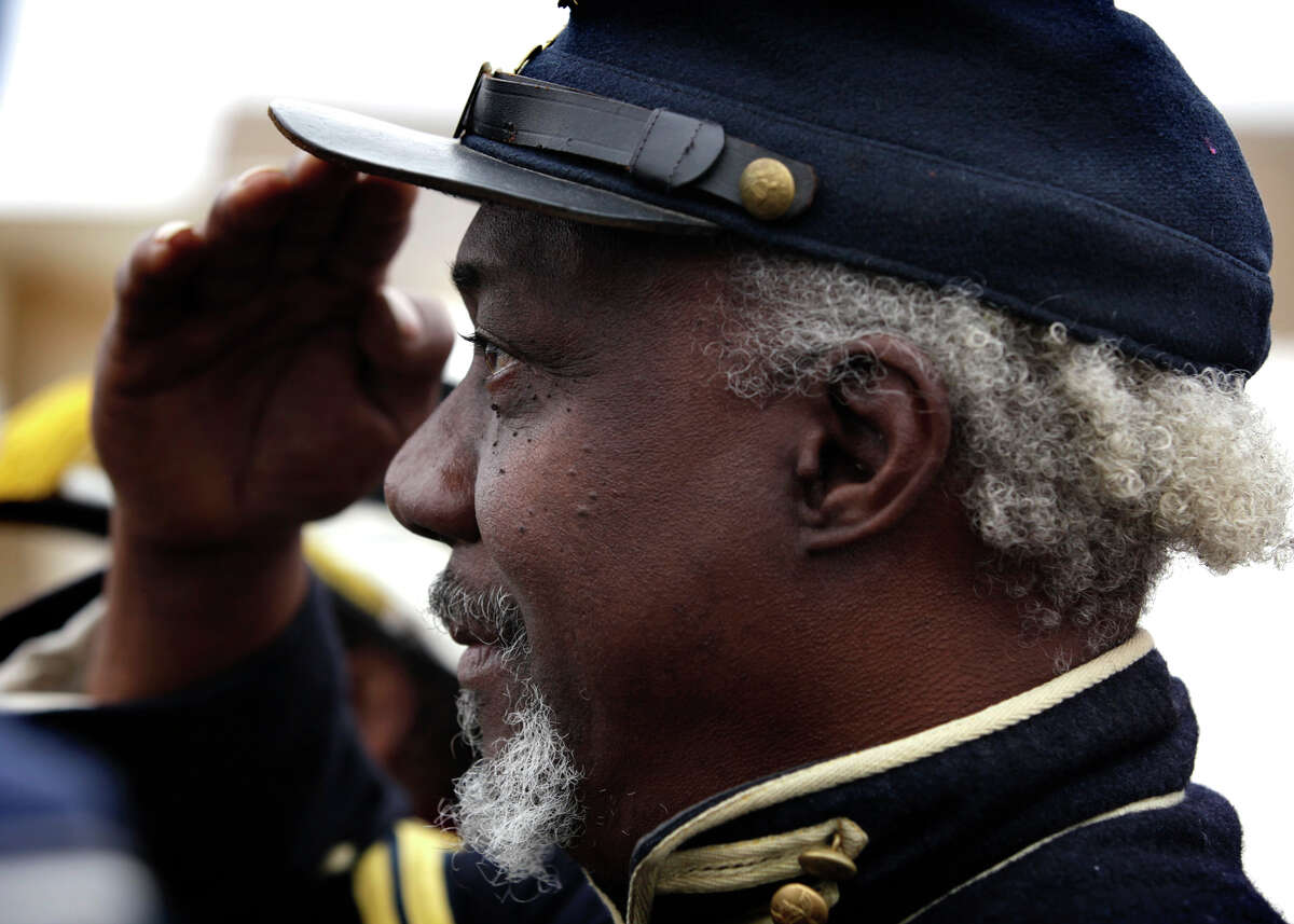 Metro daily - John Jones, President of the Buffalo Soldiers Living History and Heritage, salutes as the National Anthem is played as the 24th City of San Antonio Martin Luther King. Jr. Commemorative March reaches Pittman Sullivan Park, Monday, Jan. 17, 2011. photo Bob Owen/rowen@express-news.net