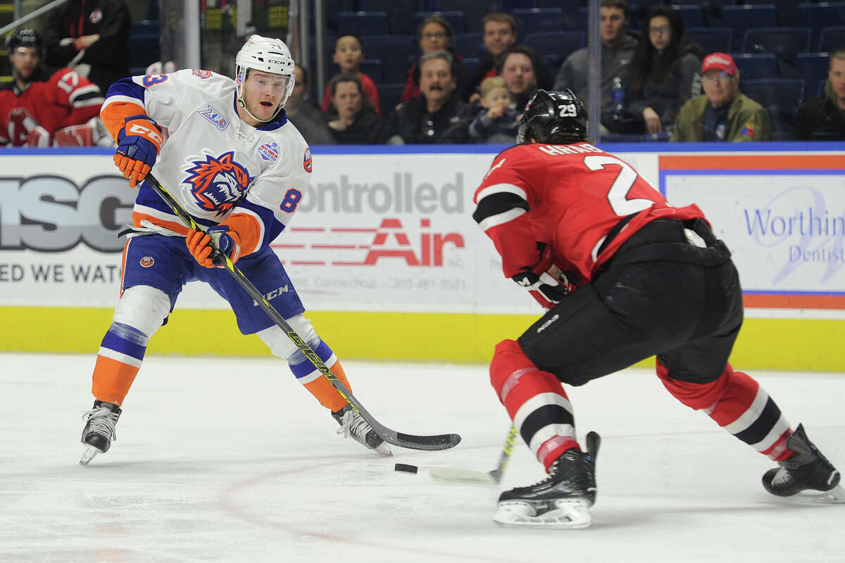 Sound Tiger Connor Jones races the puck into the offensive zone defended by Albany's Raman Hrabarenka during the first period of their AHL hockey match up at the Webster Bank Arena in Bridgeport, Conn. on Sunday, February 21, 2016.