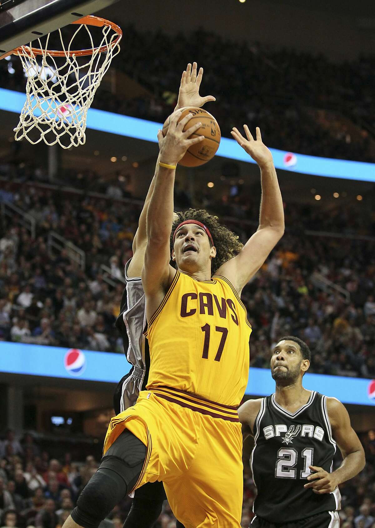 The Cleveland Cavaliers' Anderson Varejao attempts a shot as San Antonio Spurs' Danny Green, rear, fouls him in the fourth quarter on Wednesday, Nov. 19, 2014, at Quicken Loans Arena in Cleveland.