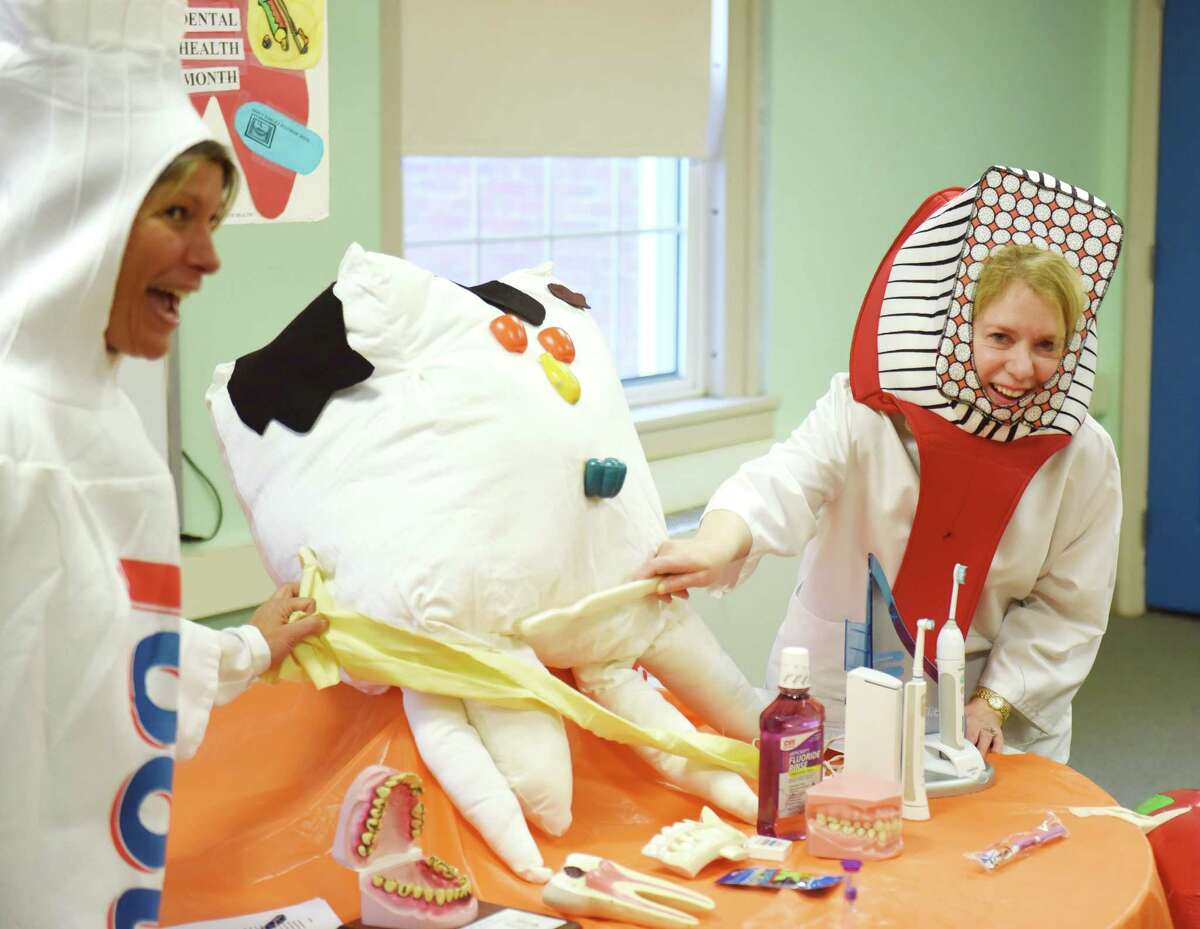 Dental hygienists Jeannie Schnakenberg, left, and Linda Conti, dressed as toothpaste and a toothbrush, brush Mr. Marshmallow Tooth to remove his plaque during a kids dental health presentation at the Boys & Girls Club of Greenwich in Greenwich. The two will hold the program again on March 2.