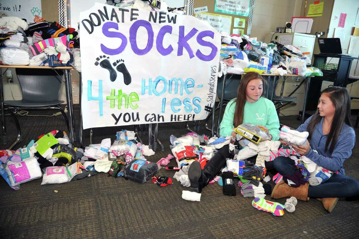 Salyards Middle School eighth-graders Kadence Holmes, left, and Bailey Snow sort by size and color socks donated through a drive organized by school teacher Angie Buck. The drive expanded to include students from other schools and garnered more than 2,500 pairs in six days.
