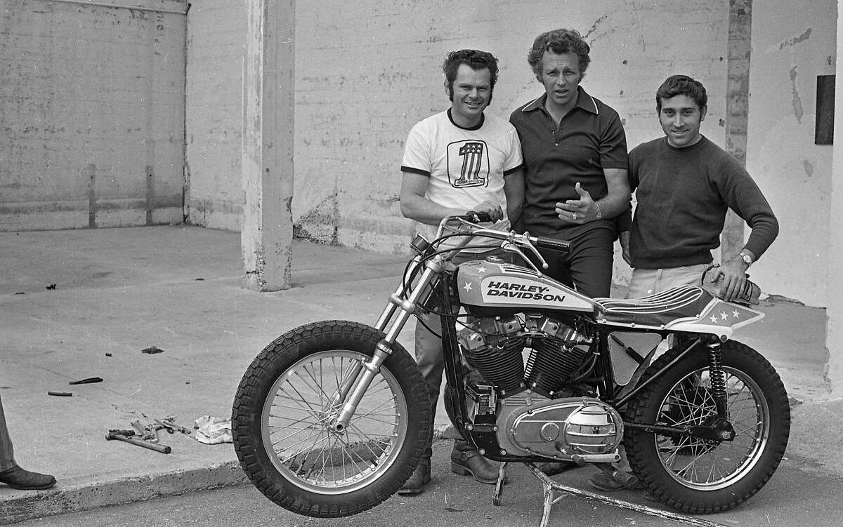 1972年3月3日，在牛宫，摩托车特技演员埃维尔·克尼维尔(中)和他的工作人员在他的哈雷戴维森旁拍照。