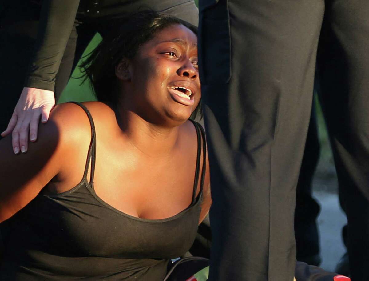 A woman cries Tuesday afternoon, Feb. 22, 2016 after arriving at the scene of a fatal shooting in the 300 block of Belmont. Three people were shot in the incident that police described as a shootout. One person died at the scene. One person was transported to SAMMC from the scene. The third victim was found near Houston and Lasoya before being transported to SAMMC. Both injured victims were in critical condition, police said.