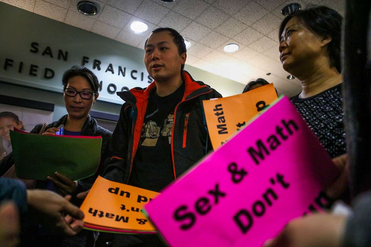 (l-r) Joanne Yow, Chong Liang Guo, and Tina Chan chat before they enter an S.F school board meeting where they will protest the ability of middle schoolers to obtain condoms at school, in San Francisco, California on Tuesday, February 23, 2016.