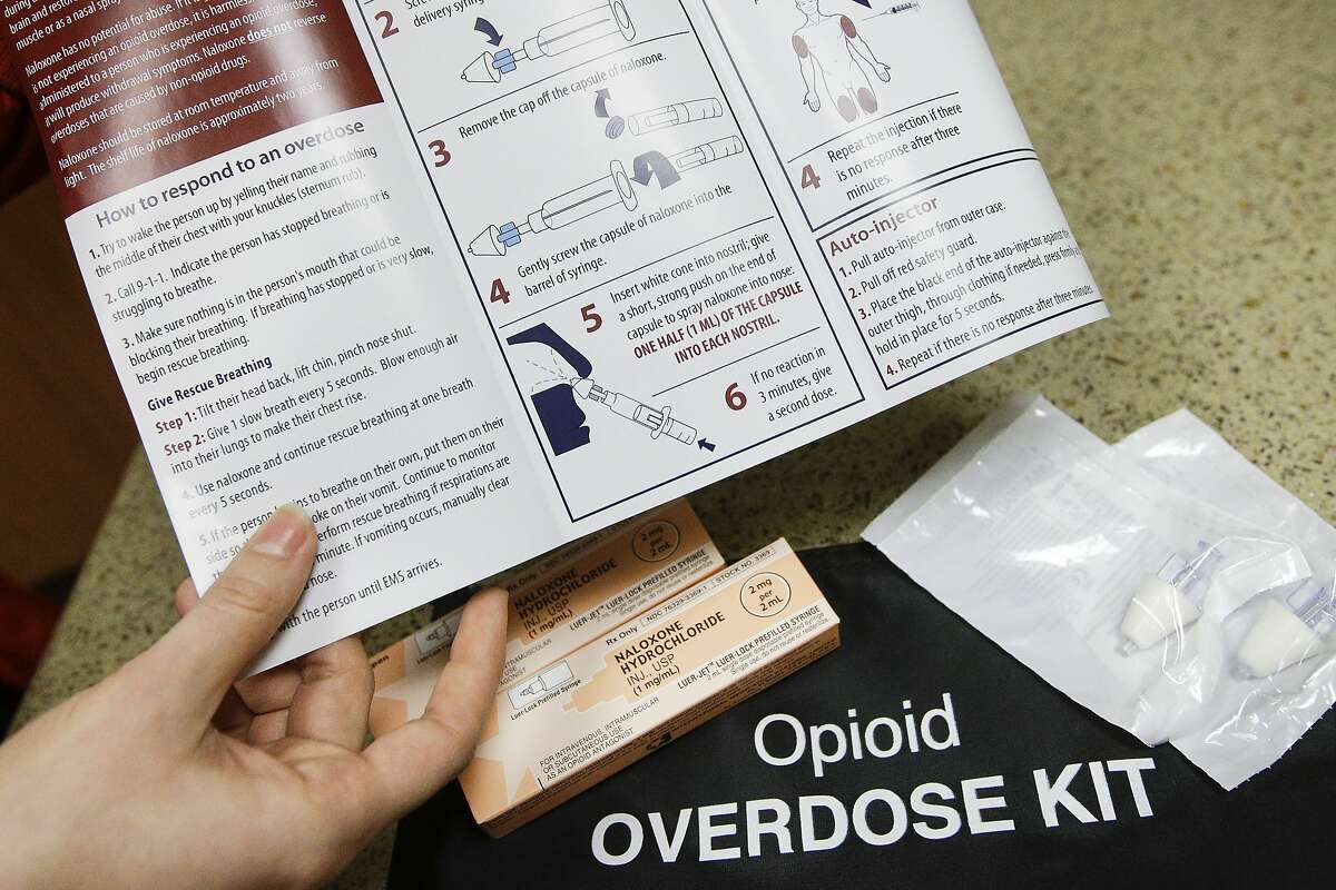 In this Tuesday, Dec. 22, 2015, photo, pharmacist Julia Landis, of Fort Hamilton Hospital, displays an opioid overdose kit in Hamilton, Ohio.