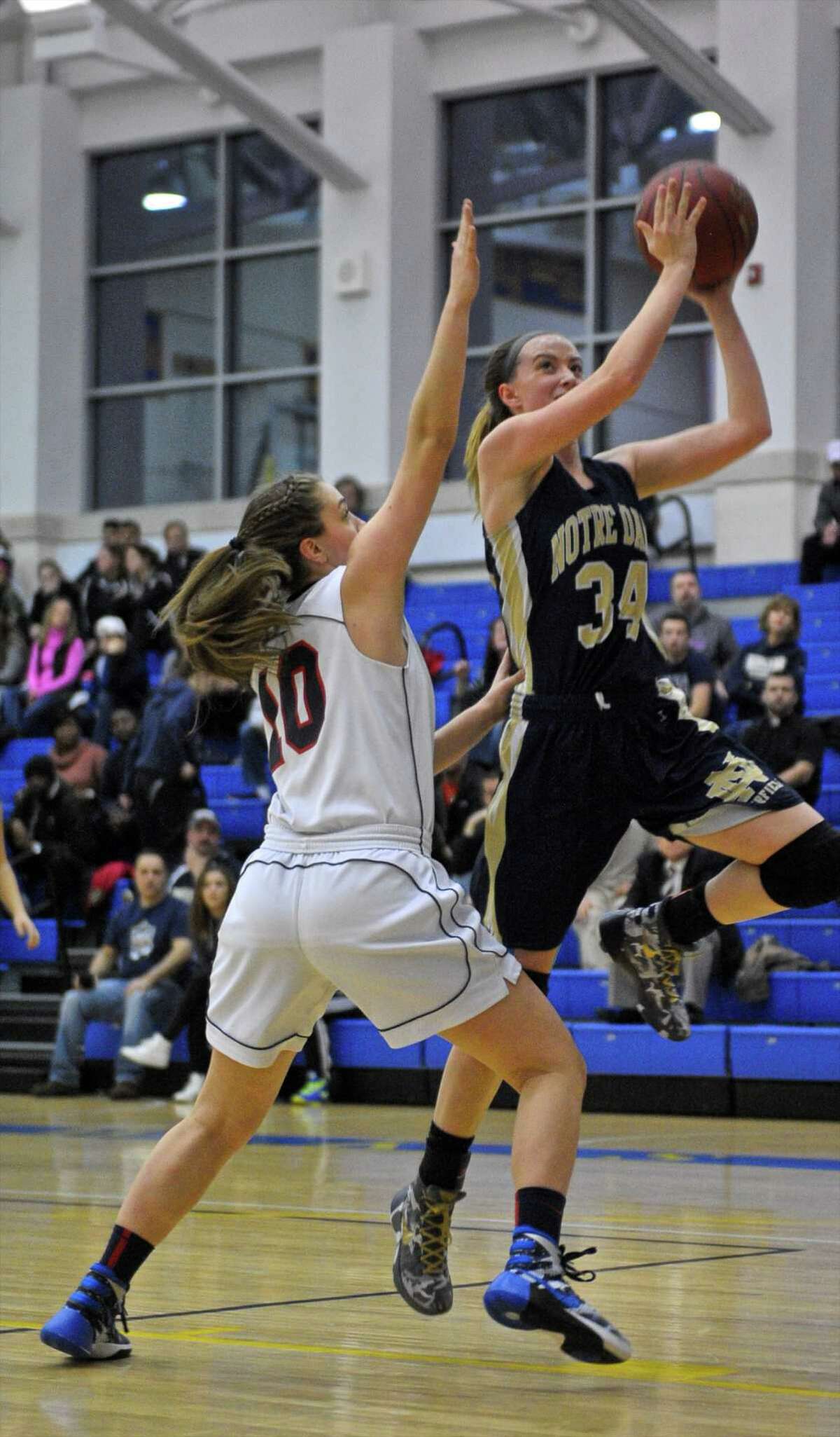 Notre Dame-Fairfield's Raina Ceryak (34) goes by New Fairfield's Sydney Gouyveia (10) on her way to the basket in the SWC girls high school championship game between Notre Dame-Fairfield and New Fairfield high school, on Wednesday night, February 24, 2016, at New Town High School, Newtown, Conn.