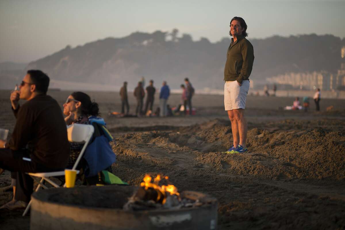 Tom Price, of Burners without Borders, poses among fire rings on Ocean Beach on Wednesday, February 24, 2016 in San Francisco, Calif. Price helped the effort to prevent the National Park Service from imposing more limitations on bonfires at Ocean Beach including requiring permits.