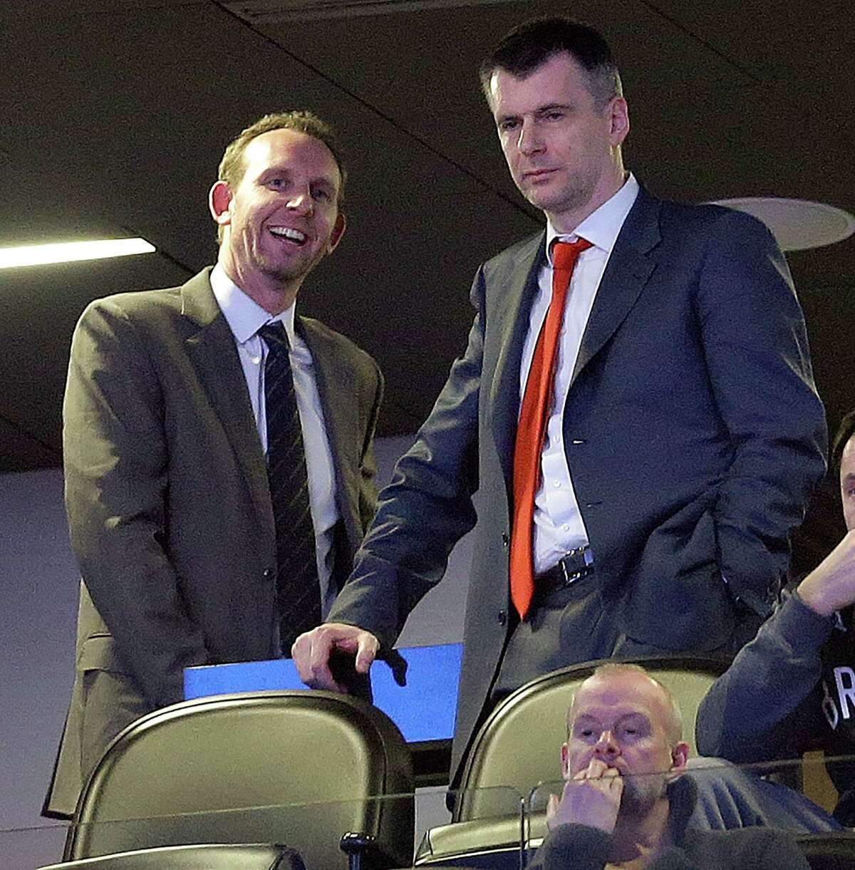 Brooklyn Nets general manager Sean Marks, left, talks with team owner Mikhail Prokhorov before an NBA basketball game between the Nets and the New York Knicks, Friday, Feb. 19, 2016, in New York. (AP Photo/Julie Jacobson)