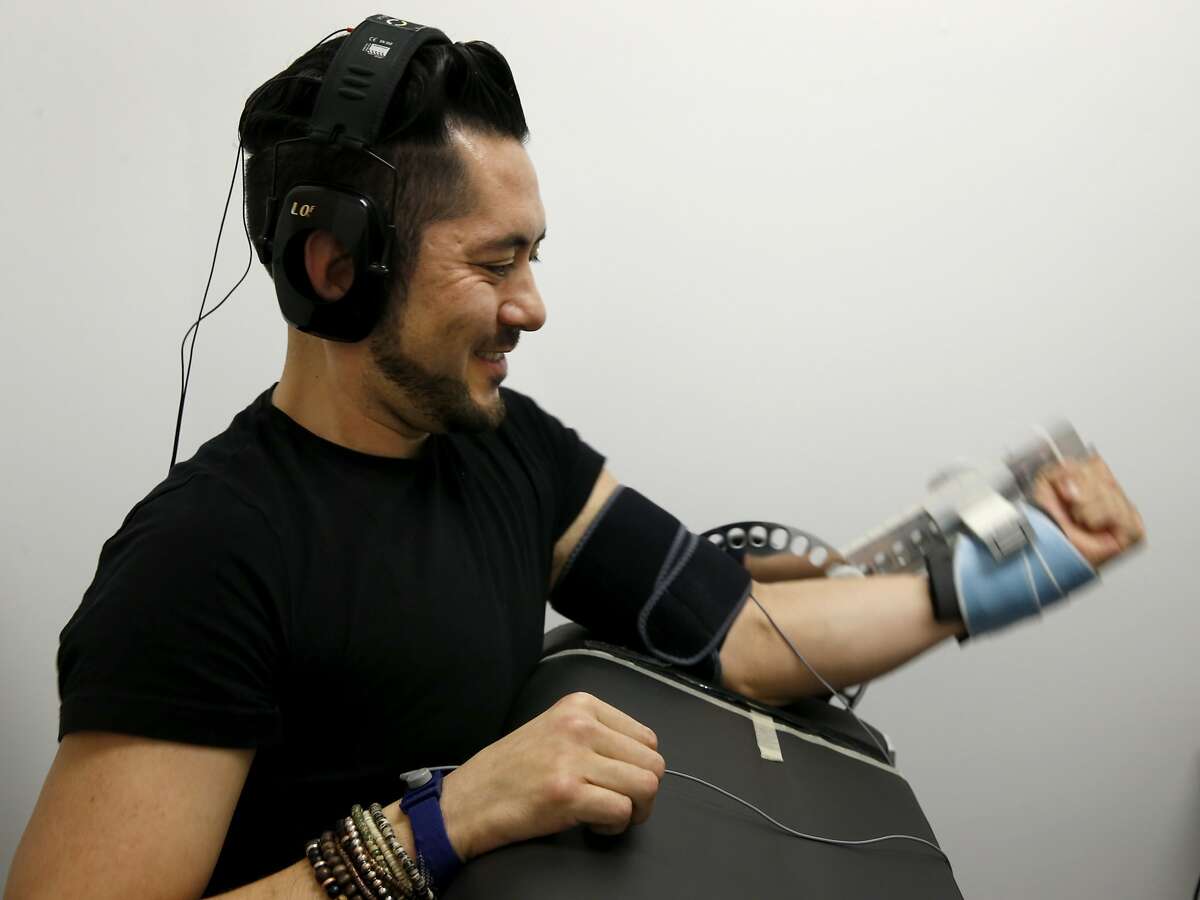 Tai Klyce performs a series of bicep curls to test the effects of Halo neuropriming headphones in San Francisco, Calif. on Wednesday, Feb. 24, 2016. Halo neuropriming headphones are being tested and used by a number of elite athletes, including Olympic skiers and Major League baseball players, during their regular training sessions. According to the company's website: "Neuropriming uses pulses of energy to increase the excitability of motor neurons, benefiting athletes in two ways: accelerated strength and skill acquisition".