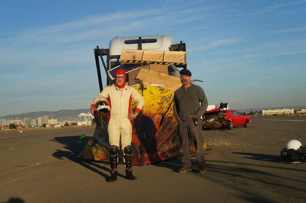 Hosts Adam Savage and Jamie Hyneman stand in front of truck wedge after it has been driven through memorabilia.