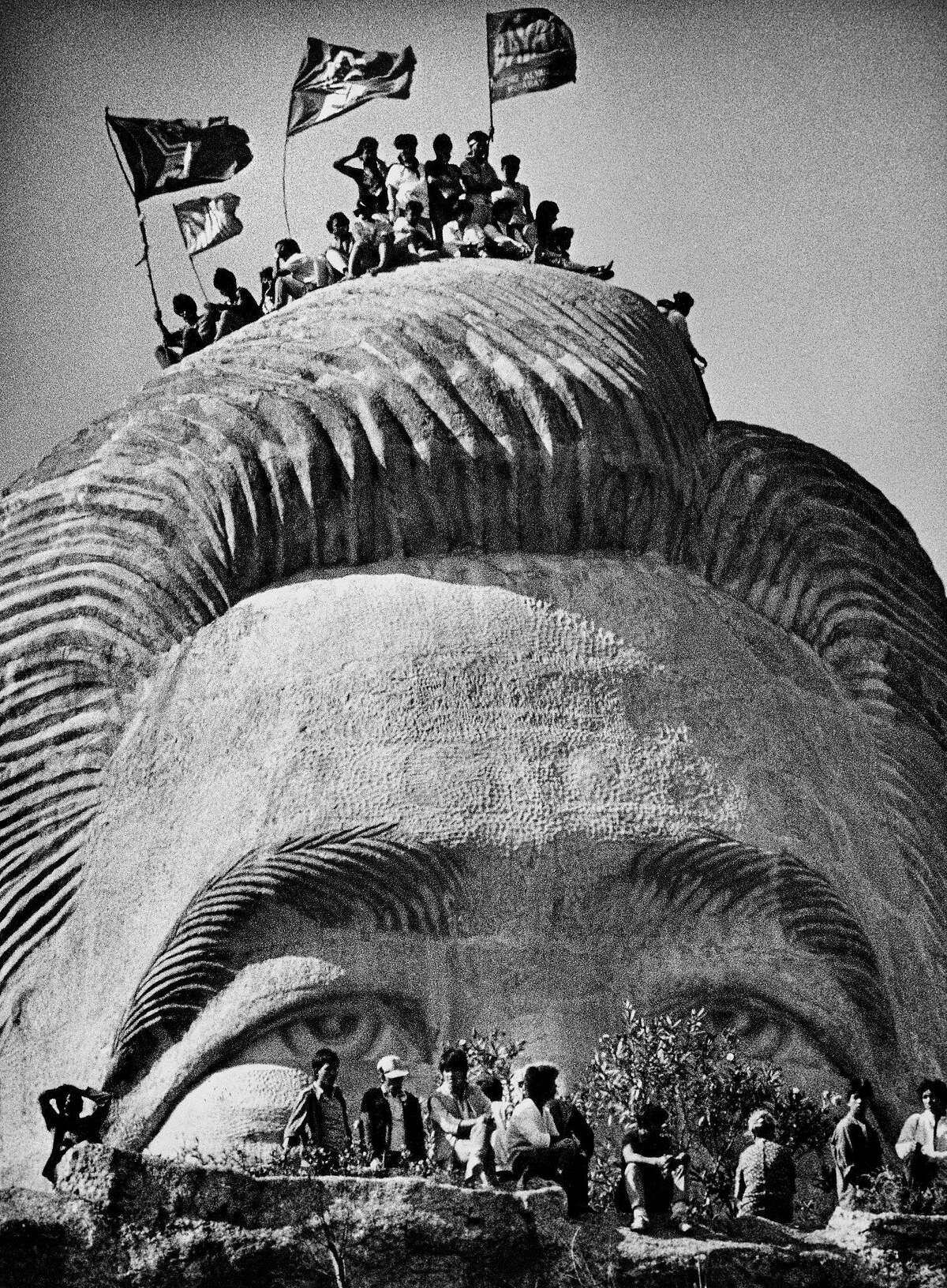 Representatives of tribal groups scale of four-story tall statue of Ferdinand Marcos in La Union Province in a rite to exorcise the former president's spirit from the statue. (Mar. 10, 1986.) Photo by Kim Komenich for the San Francisco Examiner. (Copyright, 2011, Bancroft Library/the University of California)
