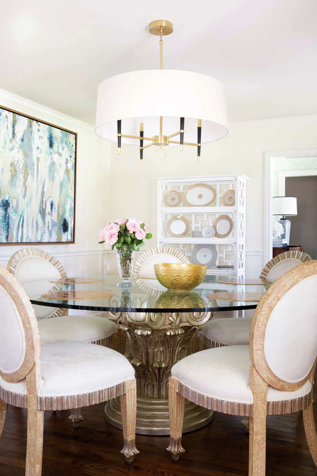 The dining room has a retro feel, with a Jonathan Adler light fixture and a round glass table that belonged to Barron's grandmother.