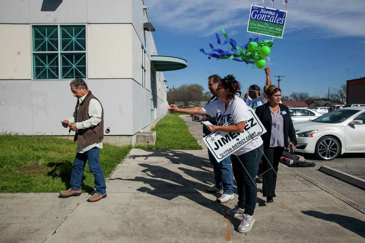 Campaign supporters voice their candidates to voters walking into Las Palmas Public Library, where voters arrived for the last day of early voting Friday Feb. 26, 2016. The polls are open from 8 a.m-8 p.m.