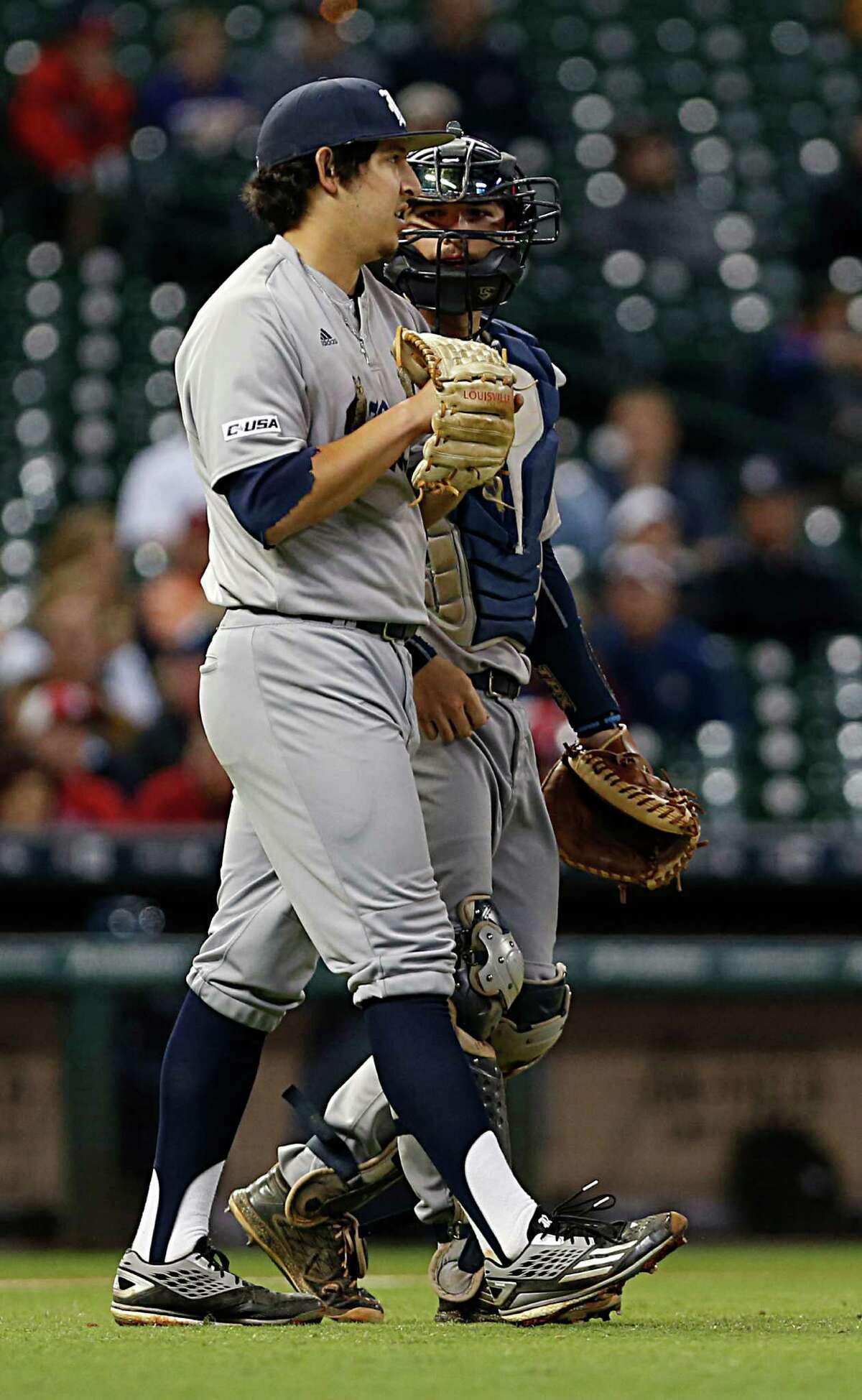 Rice pitcher Ricardo Salinas left, chats with catcher Hunter Kopycinski right, during second inning of the 2016 Shriners Hospitals for Children College Classic baseball game against TCU at Minute Maid Park Saturday, Feb. 27, 2016, in Houston.