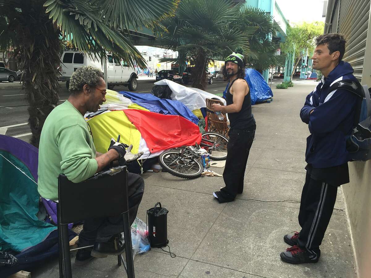 Hoyt Walker, 49, pictured left, and two friends chat near their tents under the Central Freeway in San Francisco.