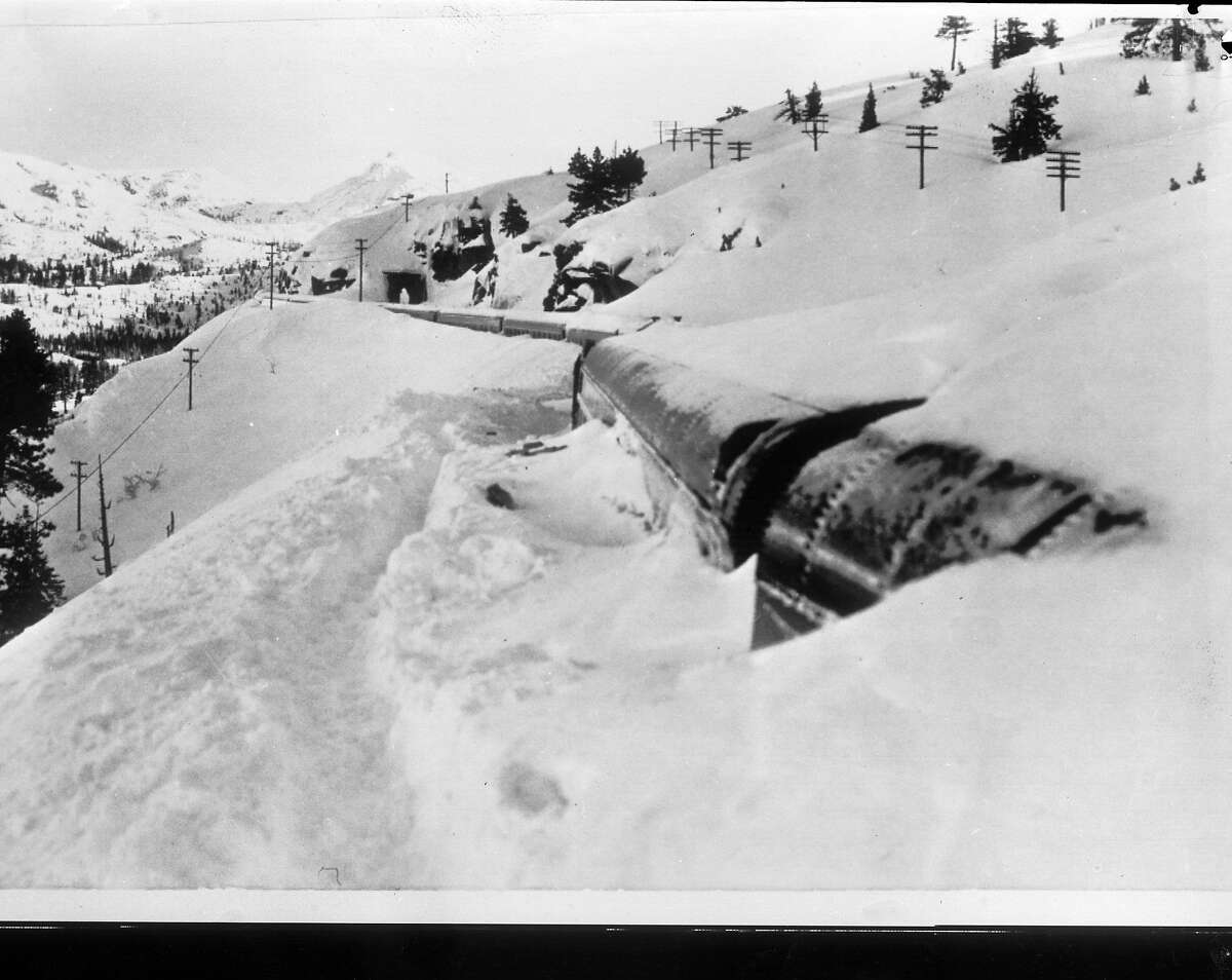 旧金山流线型列车在内华达山脉尤巴山口附近被雪堆困了4天。肯·麦克劳克林(Ken McLaughlin)穿着滑雪板和雪鞋，比其他记者早到火车站