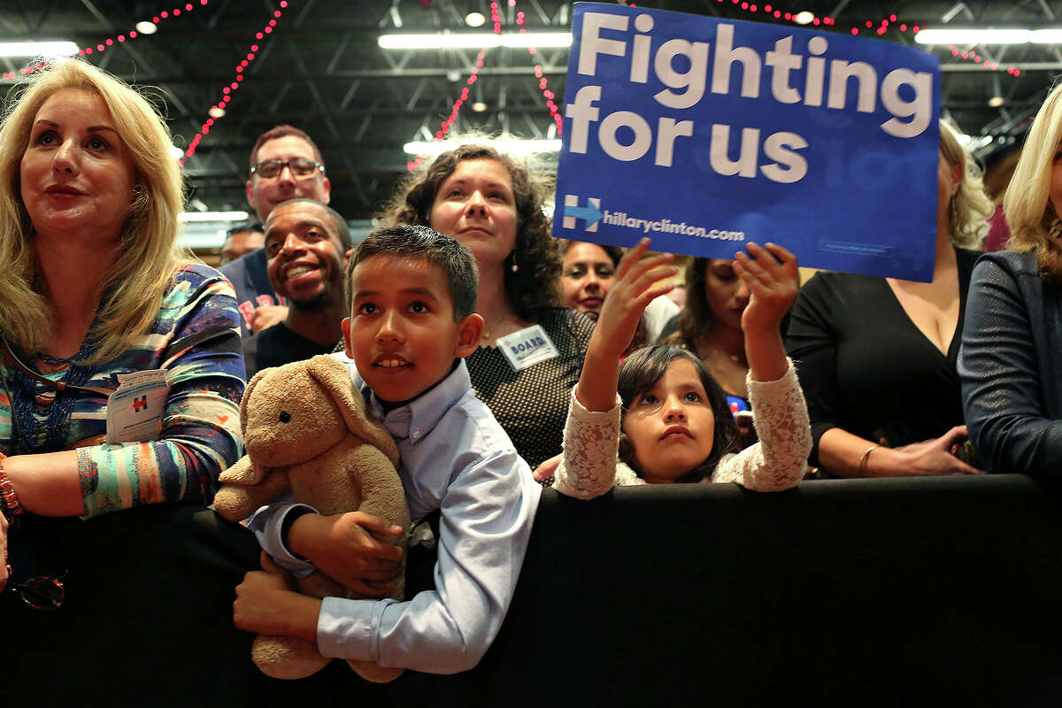 Ilan Herrera, 8, holding his Bonham Academy class pet, "Eduardo," and his sister, Alejandra Herrera, 6, listen to former President Bill Clinton speak during the Hillary for Texas Get Out The Vote Rally at the Guadalupe Cultural Arts Center Theater in San Antonio on Monday, Feb. 29, 2016.