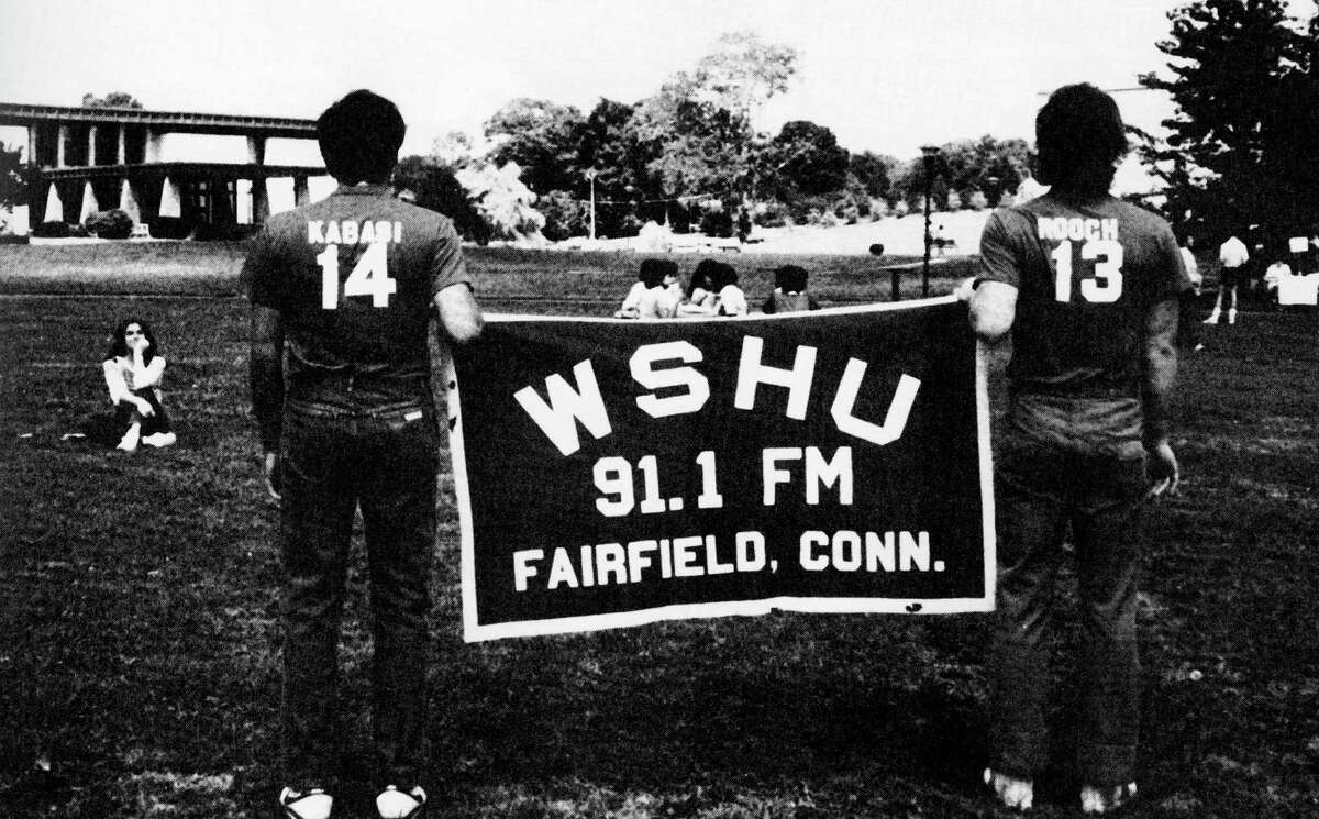 Students huold up a WSHU banner in the quad in 1984. This is the year that WSHU was accepted as a member of National Public Radio.