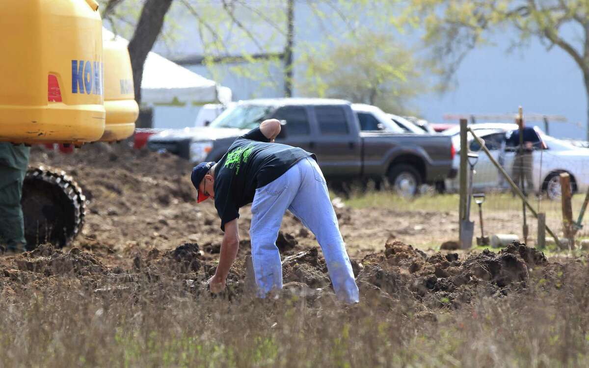 A searcher digs in a field for the remains of Jessica Cain, a teenager missing since 1997, in the 6100 block of E. Orem Dr., Wednesday, March 2, 2016, in Houston.