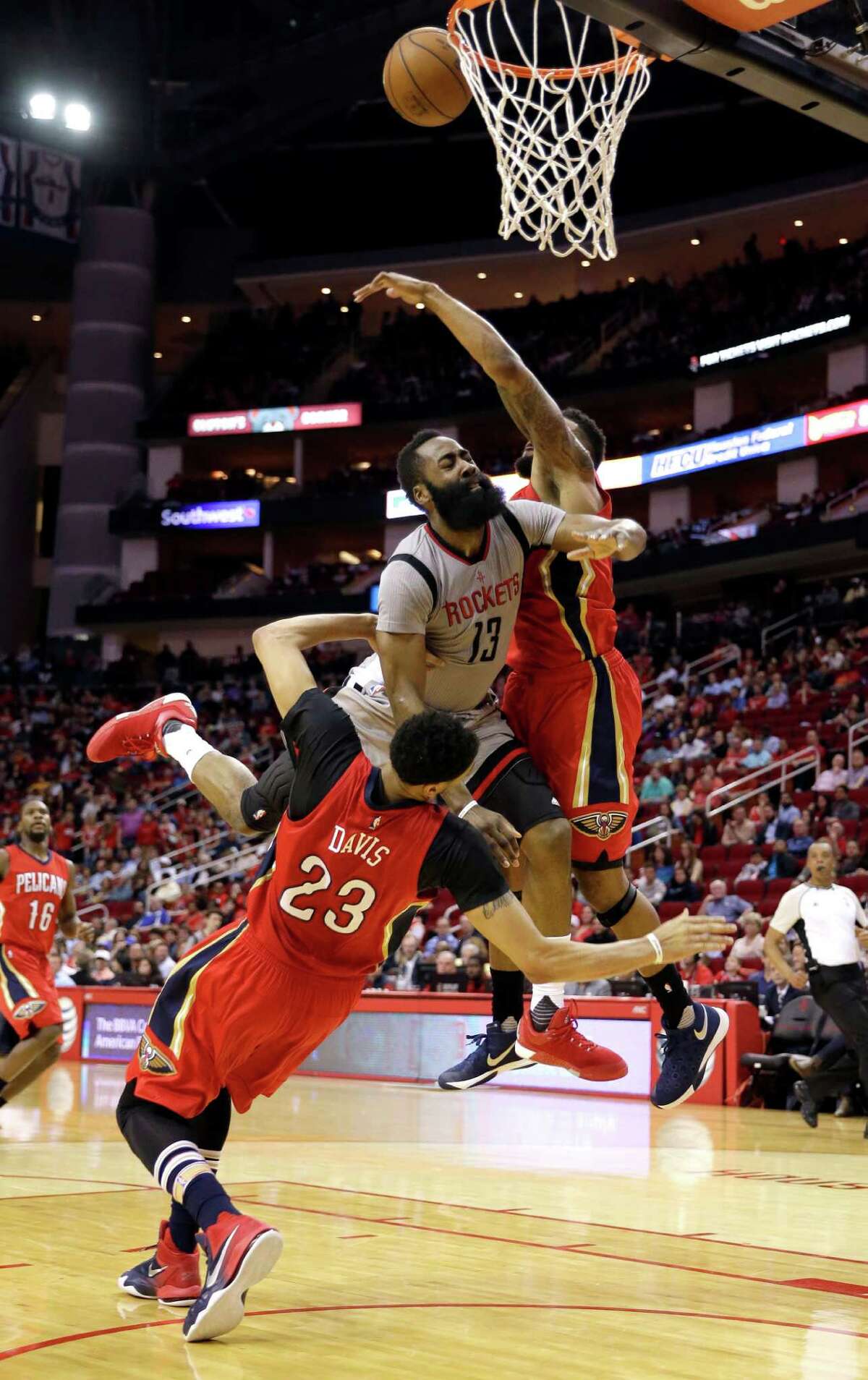 Houston Rockets' James Harden (13) charges into New Orleans Pelicans' Anthony Davis (23) as Alonzo Gee, right, helps defend during the second half of an NBA basketball game Wednesday, March 2, 2016, in Houston. Houston won 100-95. (AP Photo/David J. Phillip)