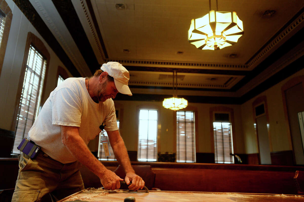 Carpenter David Weston removes the finish on a table in a courtroom at the Jefferson County courthouse on Tuesday afternoon. Two courtrooms in the old courthouse were damaged by termites. Photo taken Tuesday 3/1/16 Ryan Pelham/The Enterprise