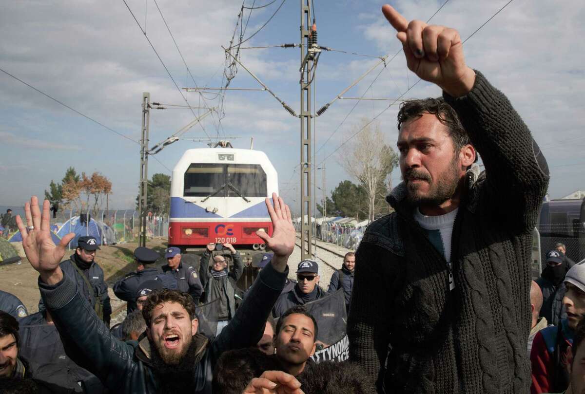 Migrants shout slogans while blocking a railway during the protest demanding the opening of the border between Greece and Macedonia in the northern Greek border station of Idomeni, Thursday, March 3, 2016. Thousands of refugees and migrants wait on the border between Greece and Macedonia and about 30,000 refugees and other migrants are stranded in Greece, with 10,000 at the Idomeni border crossing to Macedonia. (AP Photo/Vadim Ghirda)