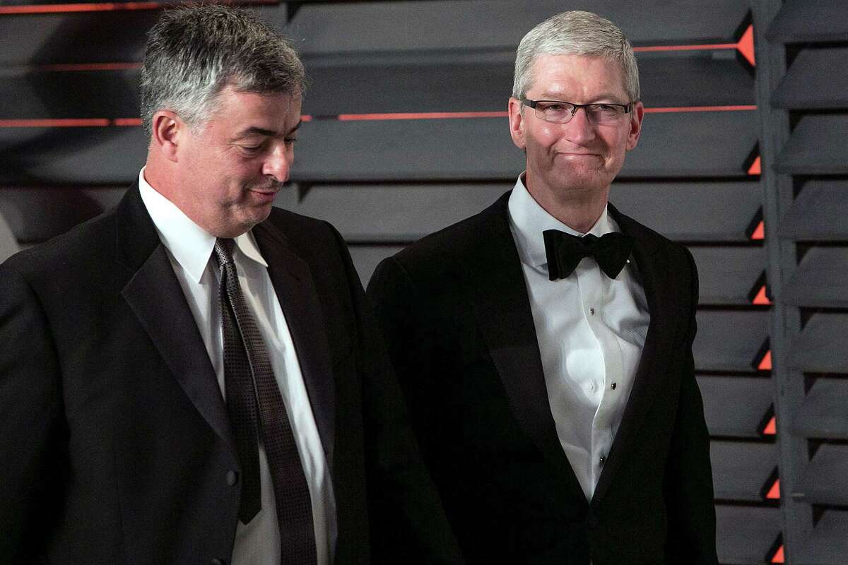 Apple Chief Executive Officer Tim Cook (right) and Apple Senior Vice President Eddy Cue arrive at an Oscar party in Beverly Hills. A reader says Apple should be fined for refusing to help the government in the San Bernardino shootings.