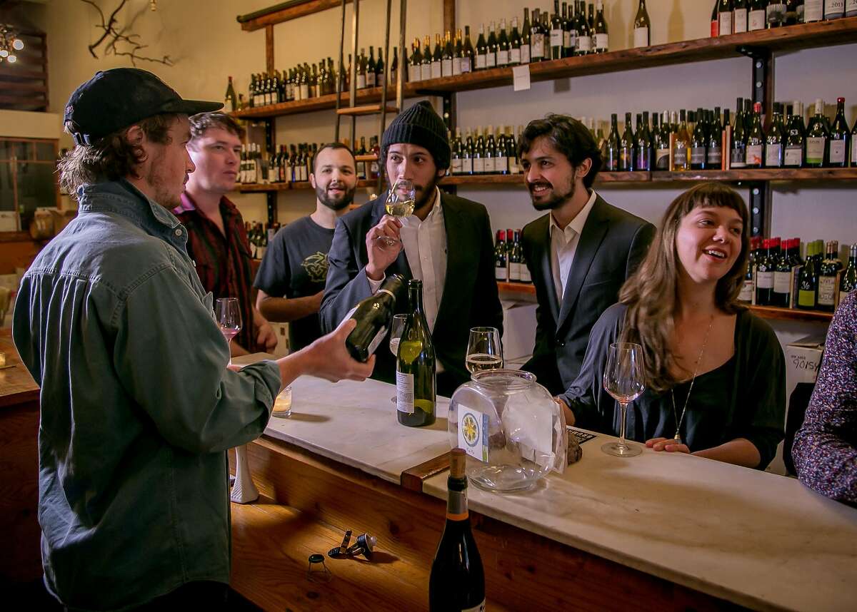 People enjoy wines at the Ordinaire wine bar in Oakland, Calif. on March 3, 2016.