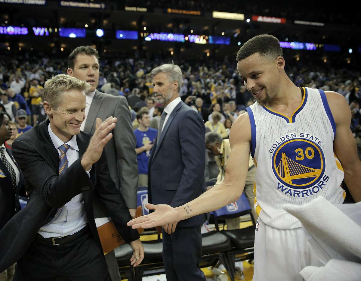 Steve Kerr and Stephen Curry (30) celebrate after the Warriors defeated the Thunder 121-106 to tie the longest home winning streak at 44 games.