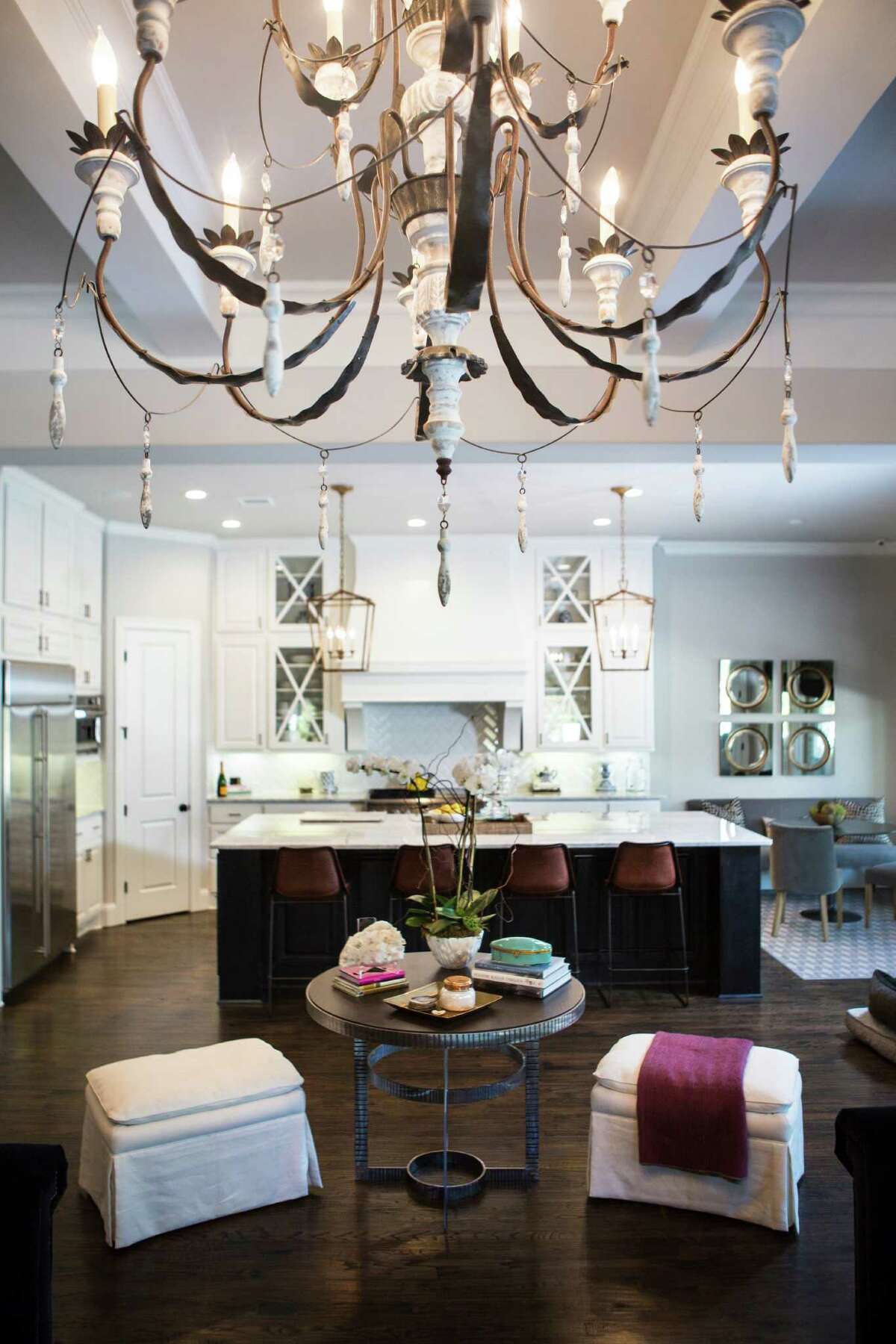 A small round table serves as a divider between the living room and open kitchen. The kitchen, with its marble island and white cabinets, is big and bright and helps open up the back half of the house.