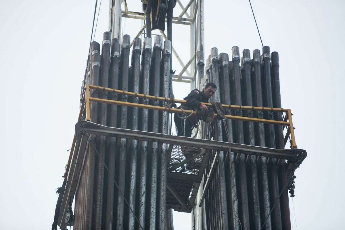 An oil field worker posiitons himself in the derrick position on an oil rig in Hallettsville, Texas on May 22, 2015. The drill collars stand next to him. Oil companies expect to spend billions more next year on drilling wells and pumping oil across the United States, a financial boost for firms that sell tools and equipment, farm out crews for rigs and fracking fleets and employ thousands across Texas.