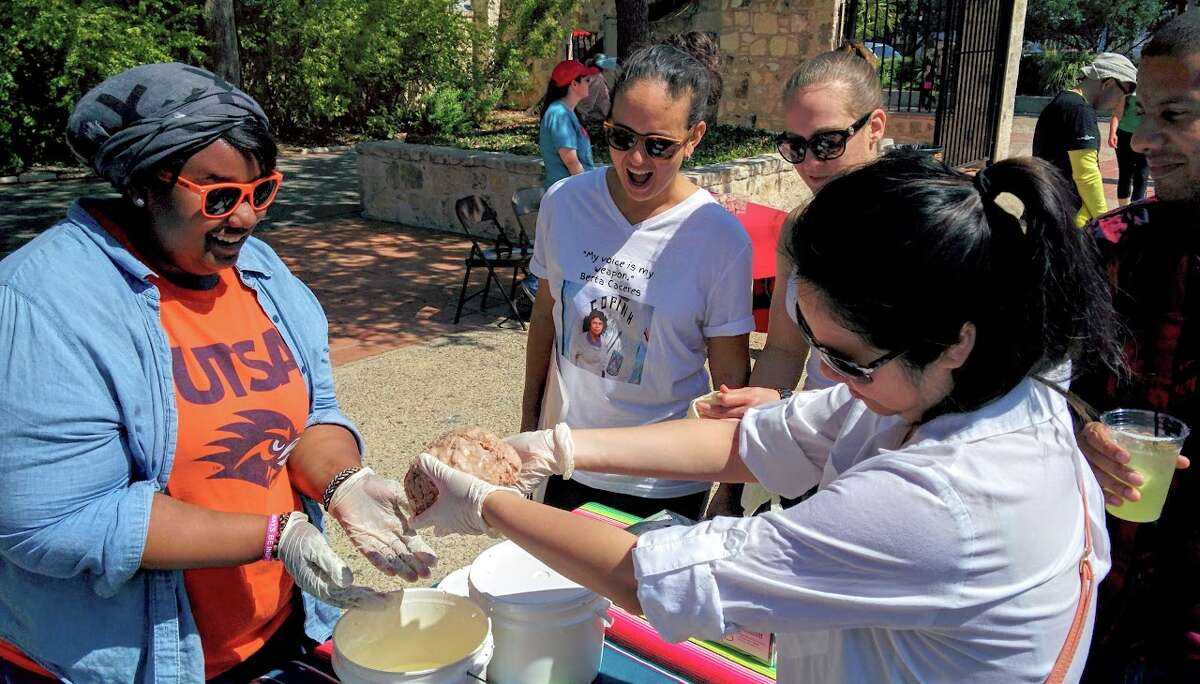 Jennifer Watts (left), a member of the Society for Advancement for Chicanos/Hispanics and Native Americans in Science, handles a human brain specimen with visitors of the Science Fiesta event in downtown San Antonio on March 5, 2016. The goal of the event is to open conversations between scientists and the general public.