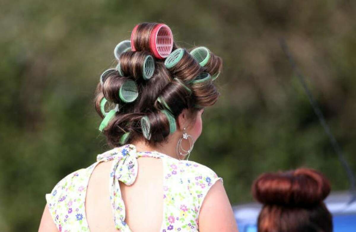 AINTREE, ENGLAND - APRIL 09: A lady dons giant curlers, the latest Merseyside fashion, outside Aintree race course in preparation for Ladies Day on April 9, 2010 in Aintree, England. Friday is traditionally Ladies day at the three-day meeting of the world famous Grand National, where fashion is as important as thne racing. (Photo by Christopher Furlong/Getty Images)
