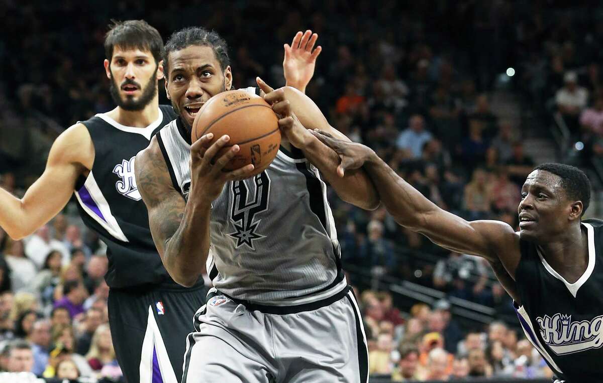 Kawhi Leonard gets fouled on a drive to the hoop by Darren Collison as the Spurs host Sacramento at the Alamodome on March 5, 2016.