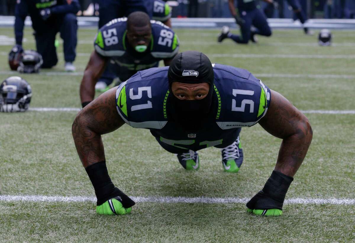 Seattle Seahawks outside linebacker Bruce Irvin wears gloves as he stretches before an NFL football game against the Pittsburgh Steelers, Sunday, Nov. 29, 2015, in Seattle. (AP Photo/Ted S. Warren)
