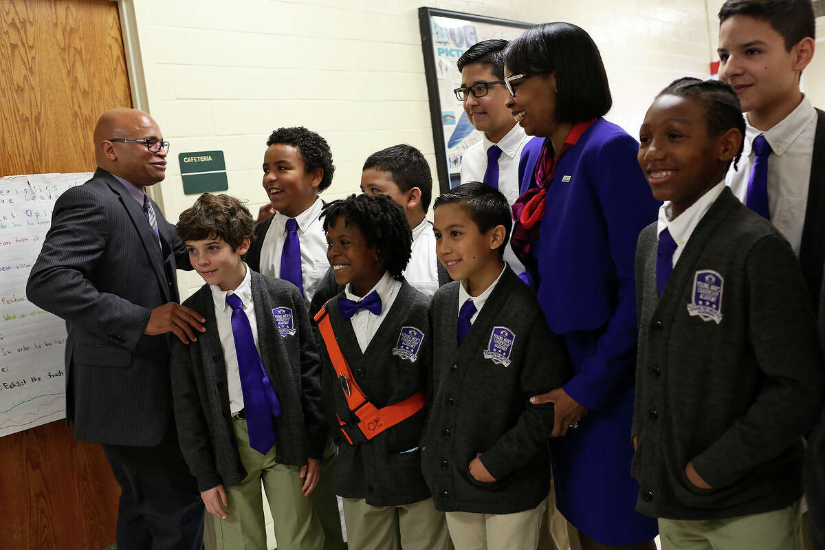 Principal Derrick Brown, far left, gathers students to join Mayor Ivy Taylor, right, for a group photo after a My Brother's Keeper San Antonio event at the Young Men's Leadership Academy in San Antonio last March. The students greeted guests and gave tours of their school.