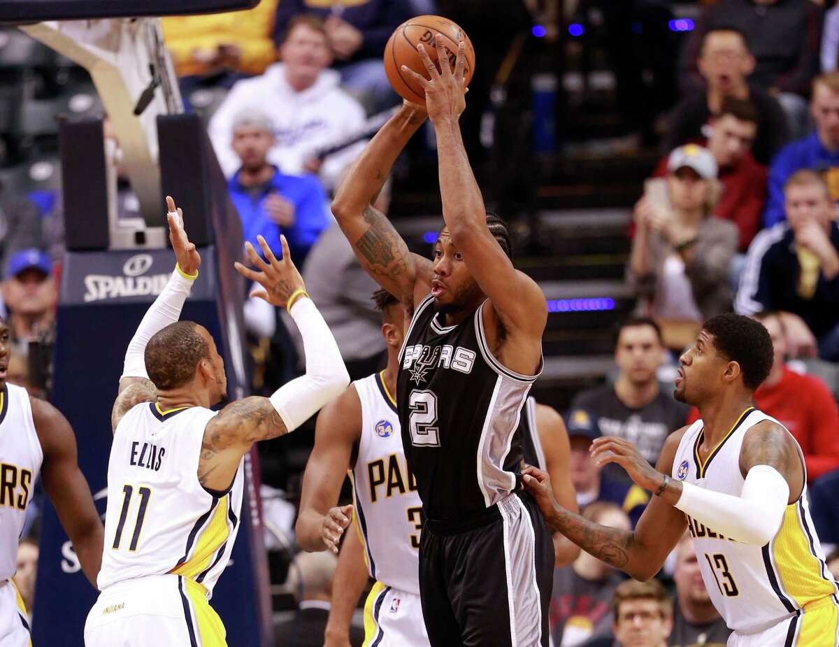 San Antonio Spurs forward Kawhi Leonard (2) passes the basketball between Indiana Pacers guard Monta Ellis (11) and Pacers forward Paul George (13) in the first half of an NBA basketball game, Monday, March 7, 2016, in Indianapolis. (AP Photo/R Brent Smith)