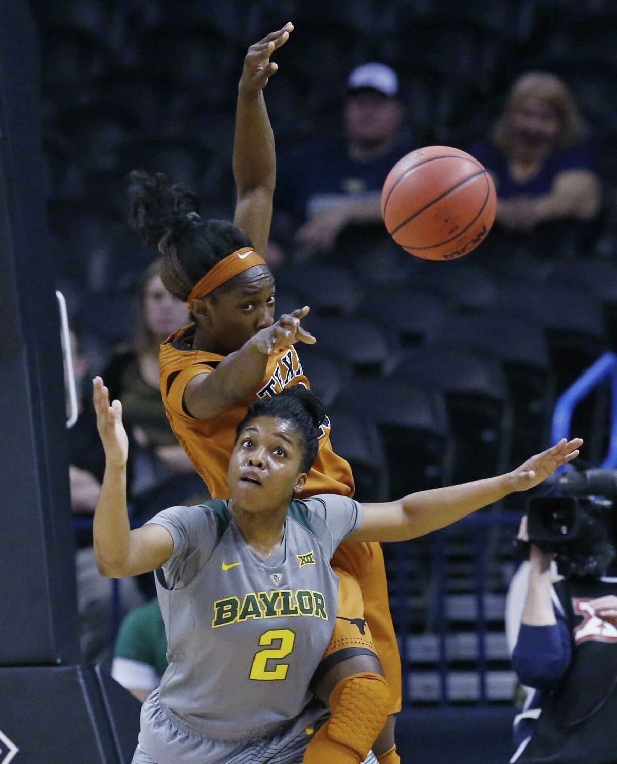 Texas guard Lashann Higgs, rear, and Baylor guard Niya Johnson (2) reach for a loose ball in the first quarter of an NCAA college basketball championship game in the Big 12 women's tournament in Oklahoma City, Monday, March 7, 2016. (AP Photo/Sue Ogrocki)