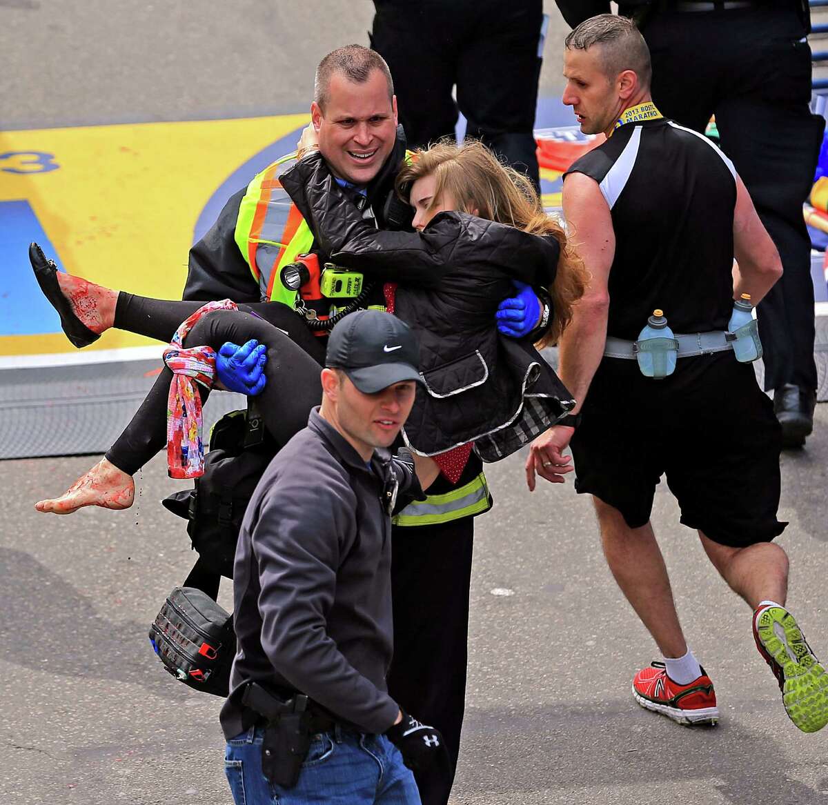 Emergency personnel aid Victoria McGrath, a Northeastern University student from Weston , Conn. after she was injured in the explosions near the finish line at the Boston Marathon on April 15, 2013.