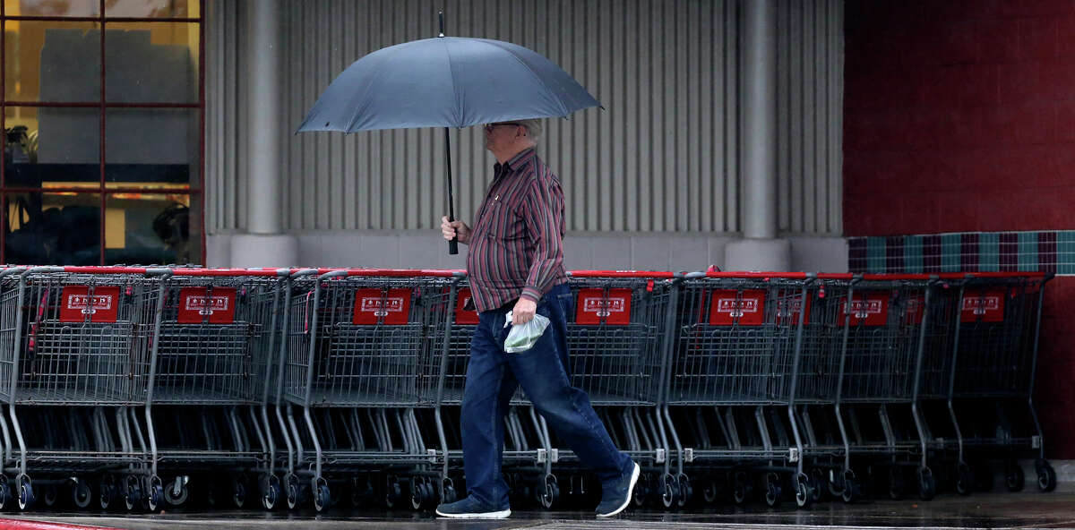 A man walks through Tuesday's drizzly morning conditions on Thousand Oaks near Jones Maltsberger. Current conditions are 67 degrees with a chance of thunderstorms.