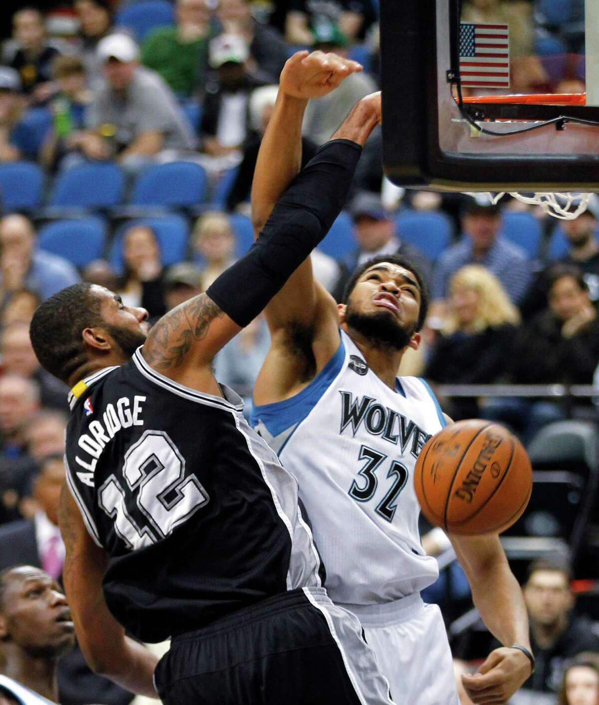San Antonio Spurs forward LaMarcus Aldridge (12) dunks in front of Minnesota Timberwolves forward Karl-Anthony Towns (32) during the first quarter of an NBA basketball game Tuesday, March 8, 2016, in Minneapolis. (AP Photo/Andy Clayton-King)