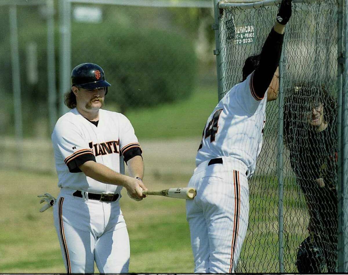 Baseball Spring Training: The SF Giants pitcher Rod Beck (L) plays butt ball with fellow pitcher Dave Burba as they chat with fans through the fence while on their way to batting practice.