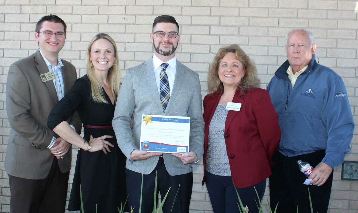 Trevor Smith (center) of Envoy Mortgage is presented with a membership certificate for joining the Central Fort Bend Chamber Feb. 11. Pictured left of Smith are Craig Kalkomey of Jones|Carter and Kathryn Robinson of Heritage Texas Properties. To Smith's right are Christa Rollock of Christa Rollock Insurance and Barry Beard of Moody National Bank-Sugar Land.