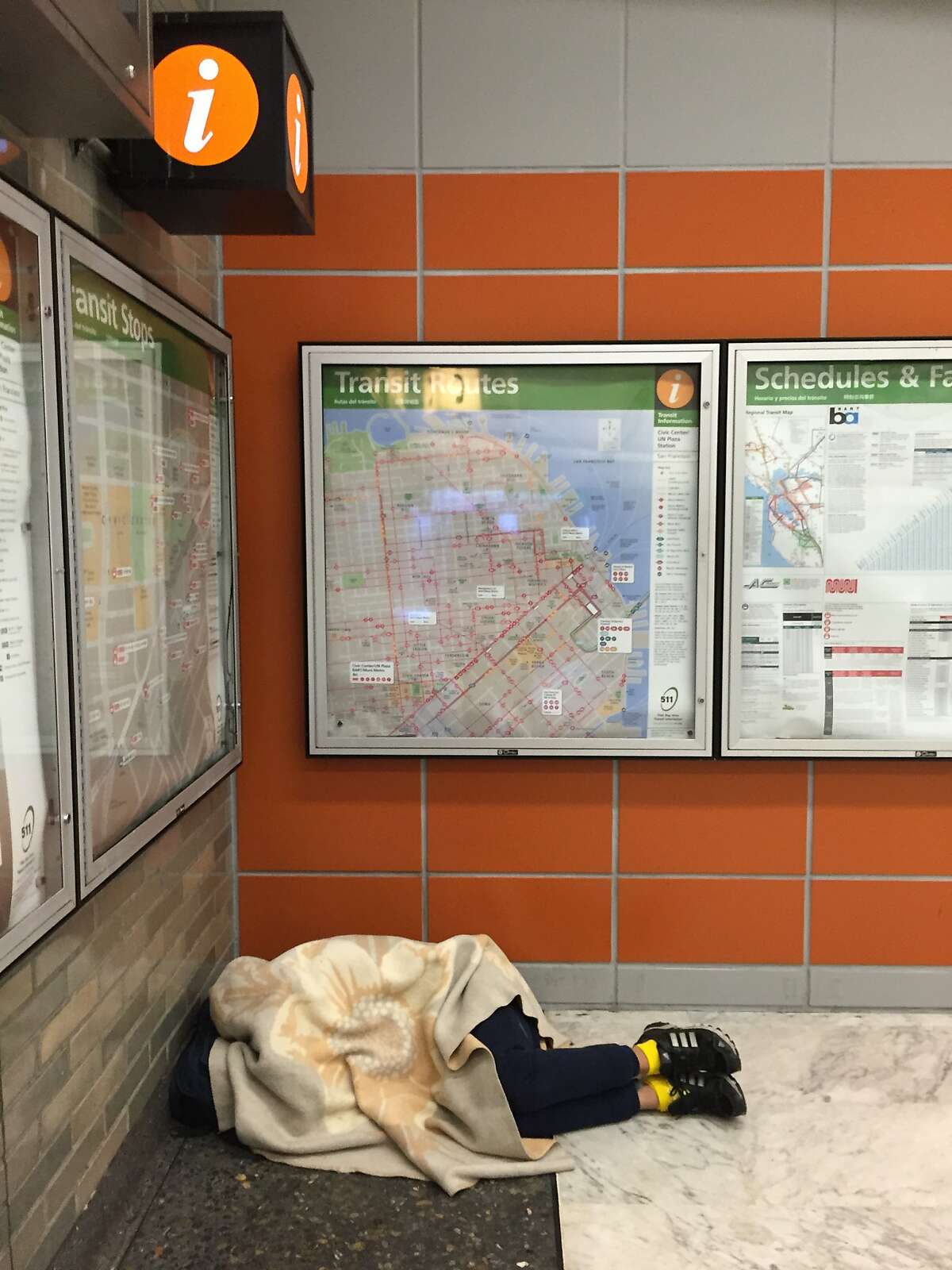 A homeless person sleeps it off inside the Civic Center BART station.