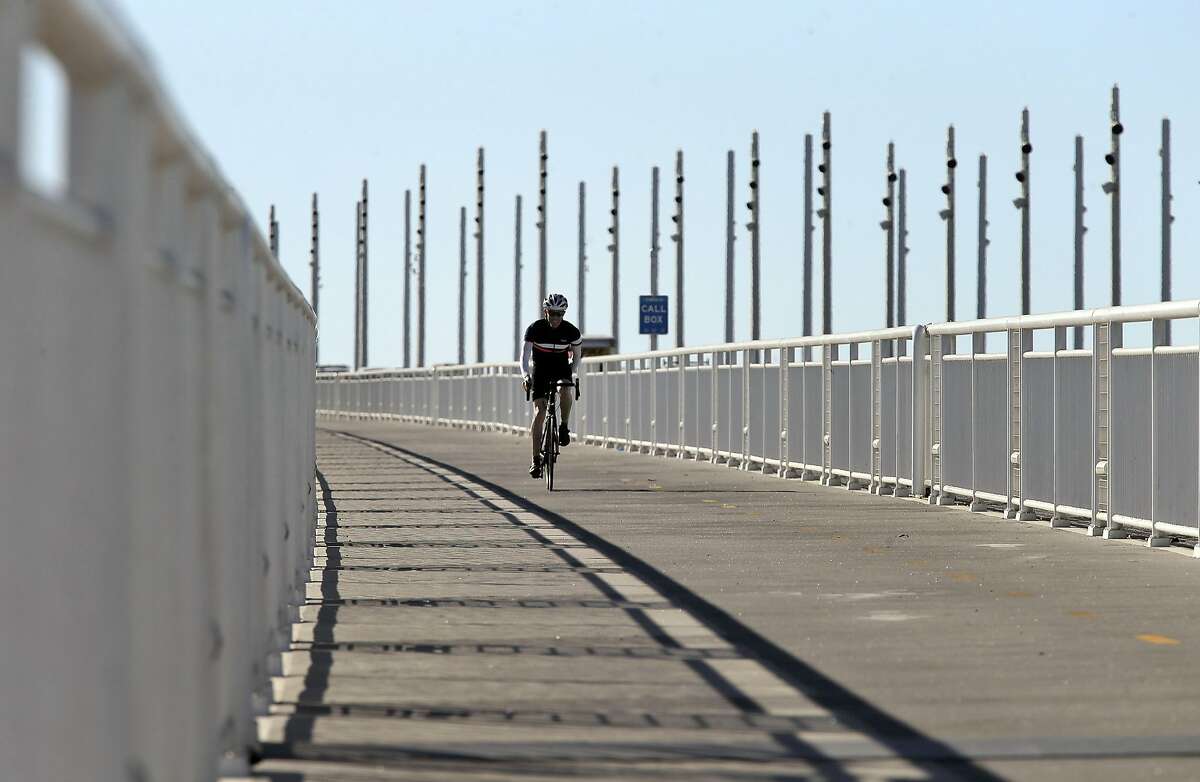 A cyclist makes his way down the Bicycle Pedestrian Path on the Bay Bridge in Oakland, Calif., on Thursday, October 29, 2015. The Bay Bridge bike path from Oakland to Treasure Island has been delayed yet again. Originally scheduled to open along with the new eastern span two years ago, completion had to wait for demolition of part of the old span, which was to be completed by summer. Then it was delayed until late fall/end of the year. Now, it looks like bike riders won't be able to pedal from the East Bay to Treasure Island until sometime next year.