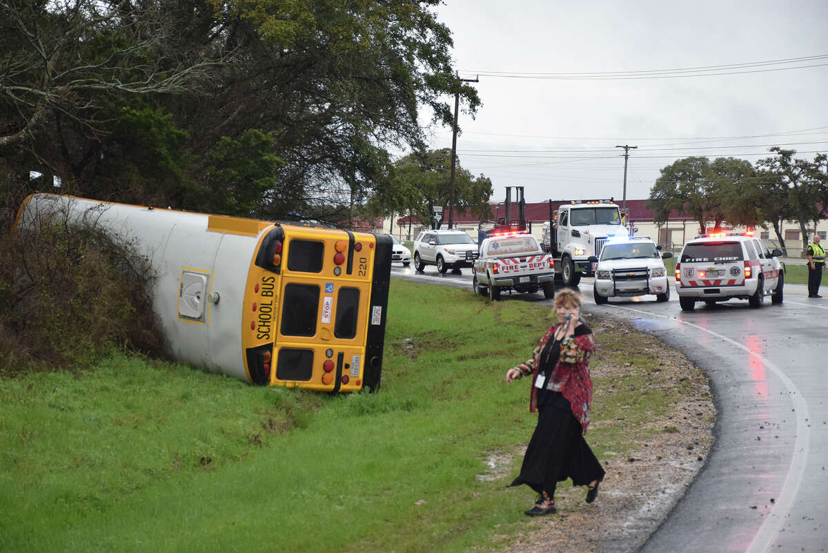 Two adults were injured Wednesday morning when a Boerne Independent School District bus bound for Champion High School hit a wet stretch of pavement and flipped on its side.