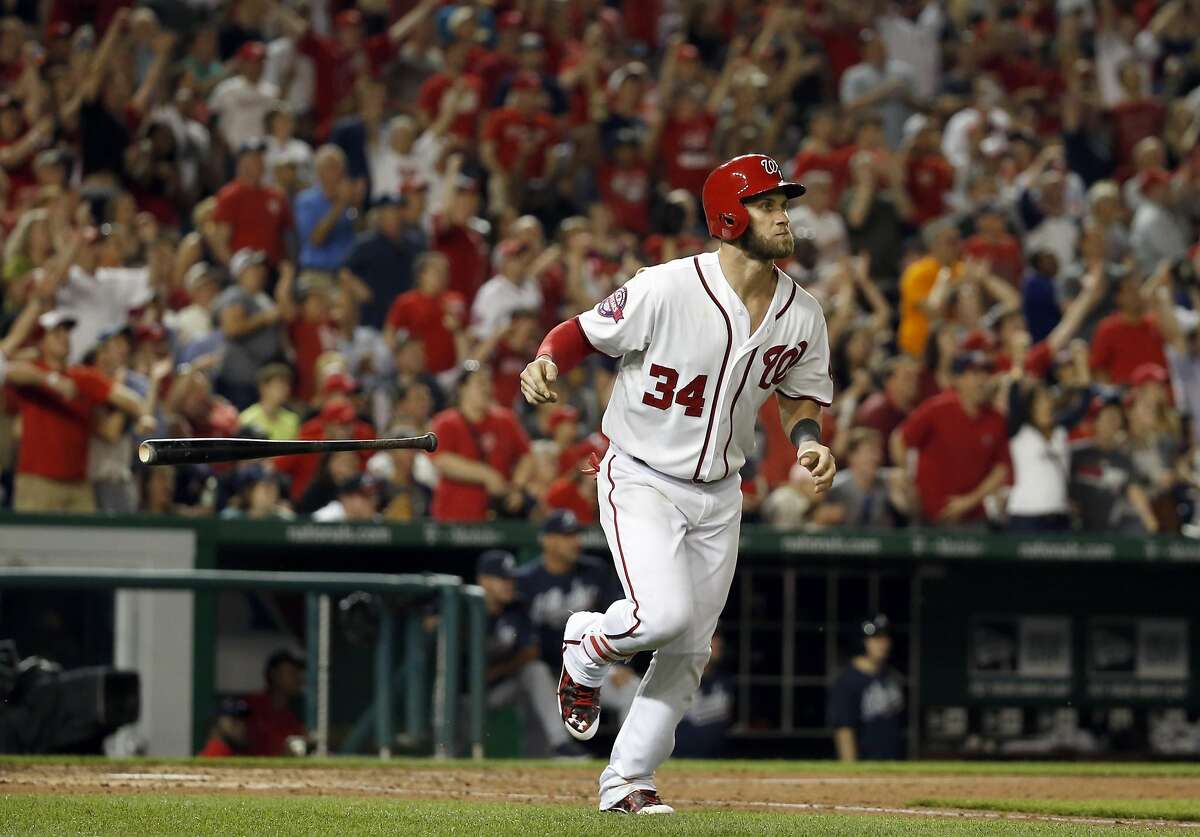 Washington Nationals' Bryce Harper (34) tosses his bat as he runs the bases for his three-run homer during the eighth inning of a baseball game against the Atlanta Braves at Nationals Park, Friday, May 8, 2015, in Washington. Harper had two homers in the game. The Nationals won 9-2. (AP Photo/Alex Brandon)