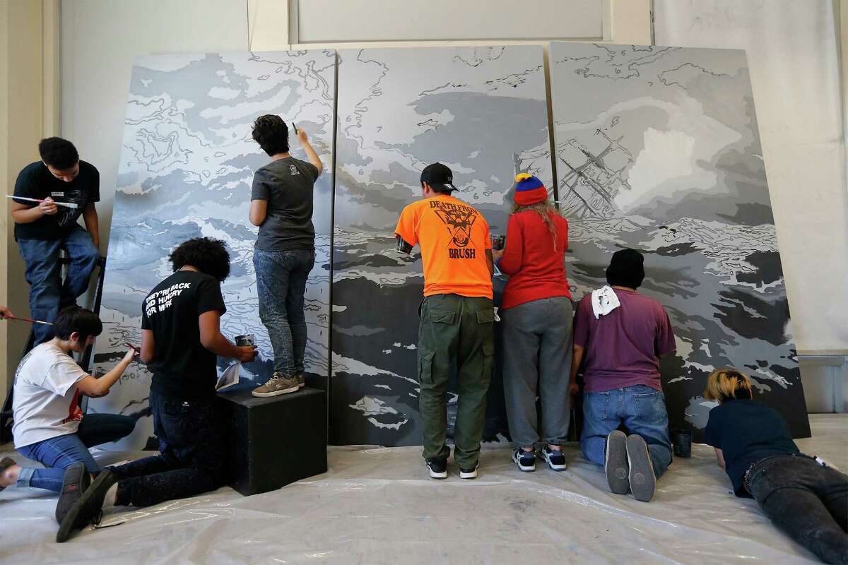 Artists Vincent Valdez and Alex Rubio work with volunteers and students to create a reproduction of a painting by Valdez depicting a ship in stormy seas. It will be placed on display at the Palmetto Center for the Arts at Northwest Vista College. The project was made possible by a grant from the National Endowment for the Arts and with support from Jerry's Artarama according to officials. (Kin Man Hui/San Antonio Express-News)